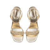 Kibele Sahara Ankle Cross Sandal in shimmering metallic leather with intricate embroidery and a stiletto heel, perfect for elegant occasions.