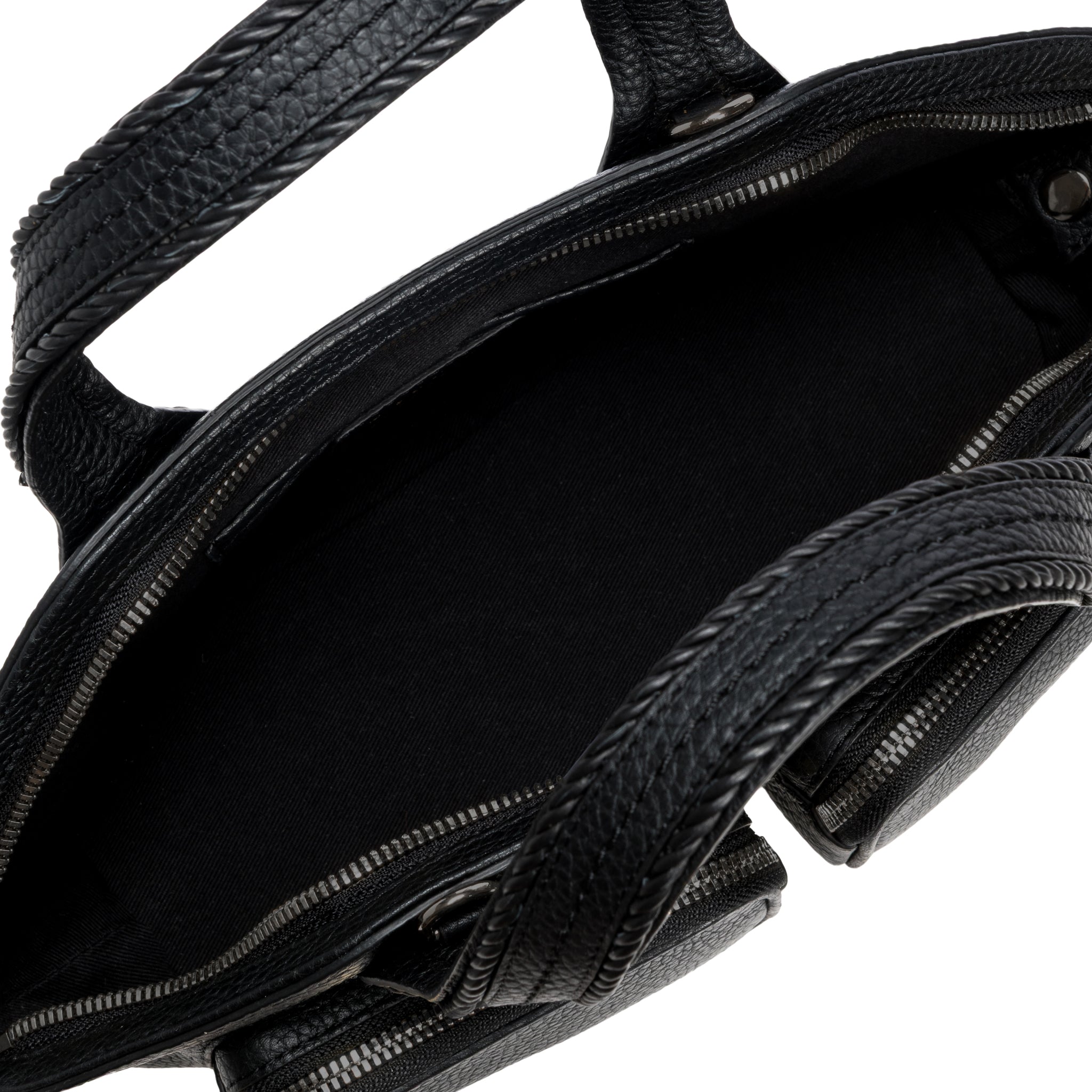 Close-up of a black leather handbag with braided handle on a white background