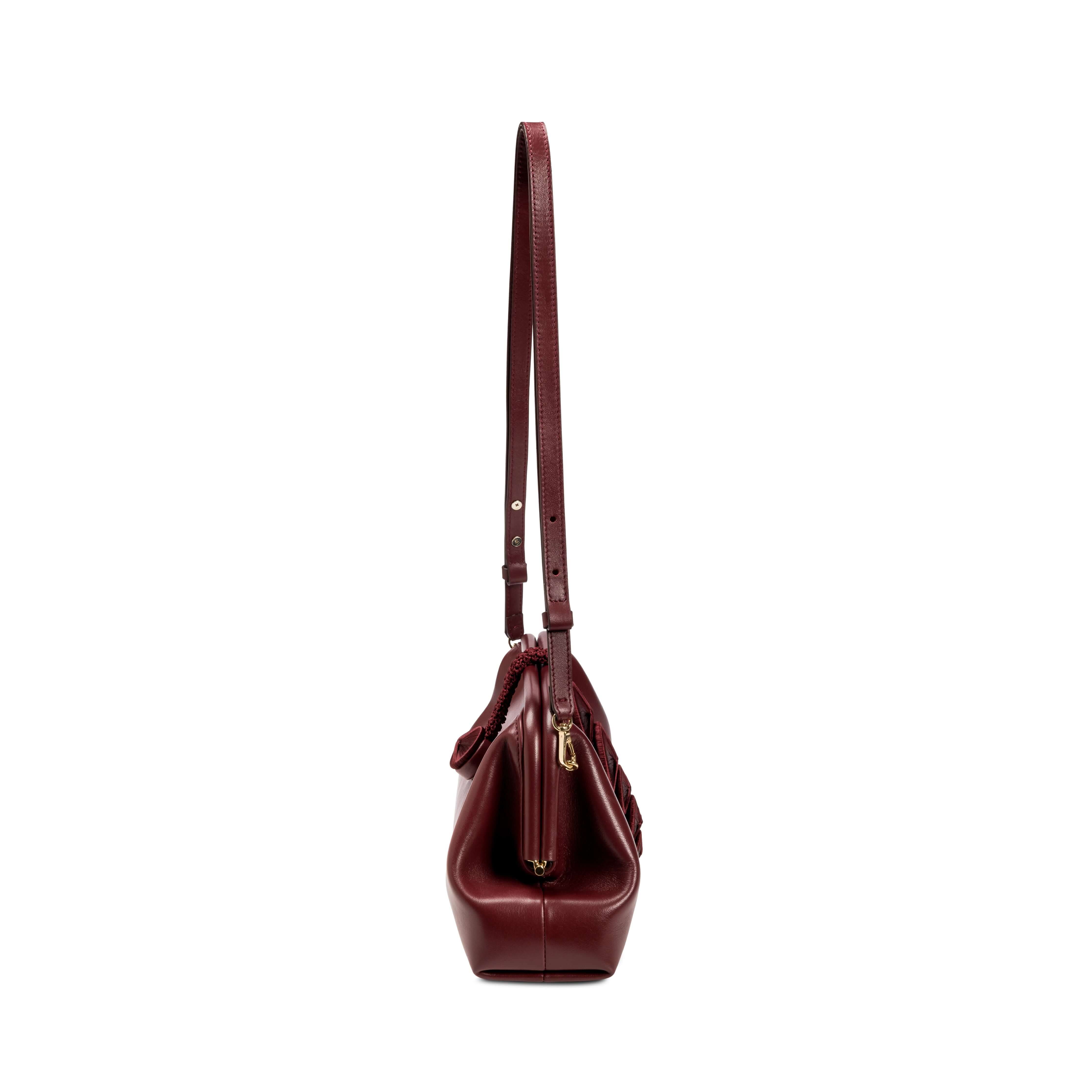 Side view of Alessa Burgundy Pouch Bag showcasing its stylish design and adjustable shoulder strap.