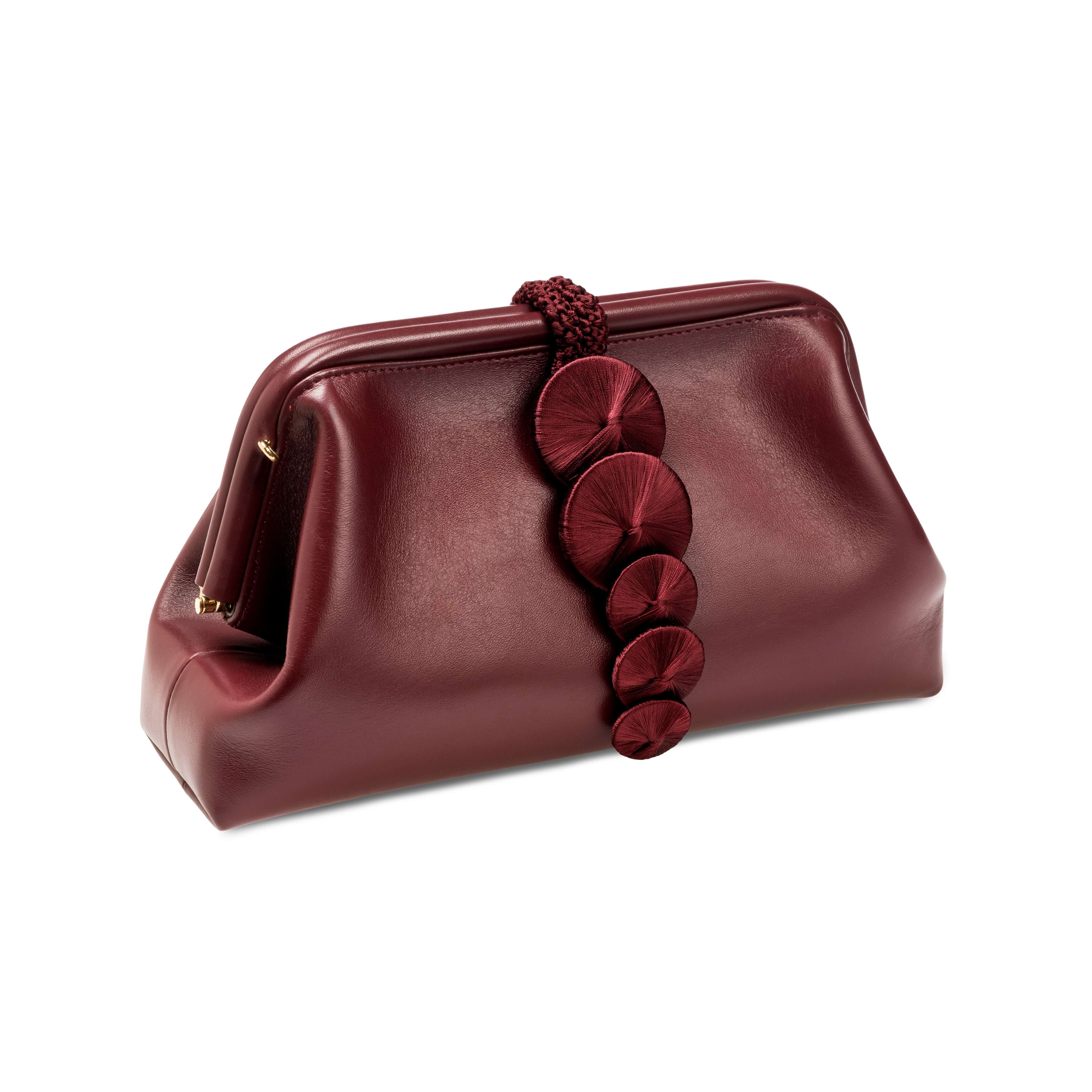 Stylish Alessa burgundy pouch bag featuring a charming decorative clasp, perfect for elegant outings.
