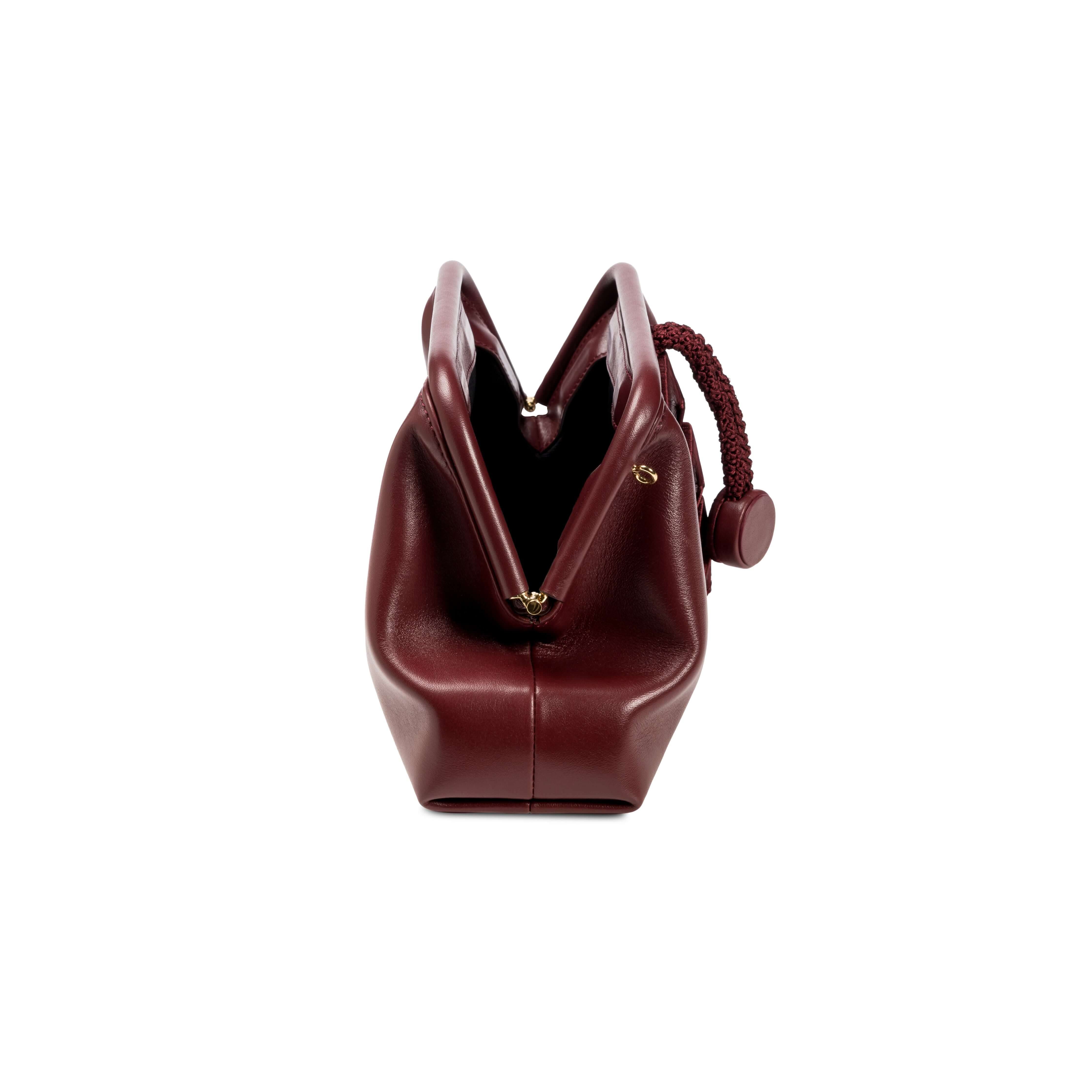 Alessa Burgundy Pouch Bag showcasing its unique design and elegant shape, perfect for stylish outings.