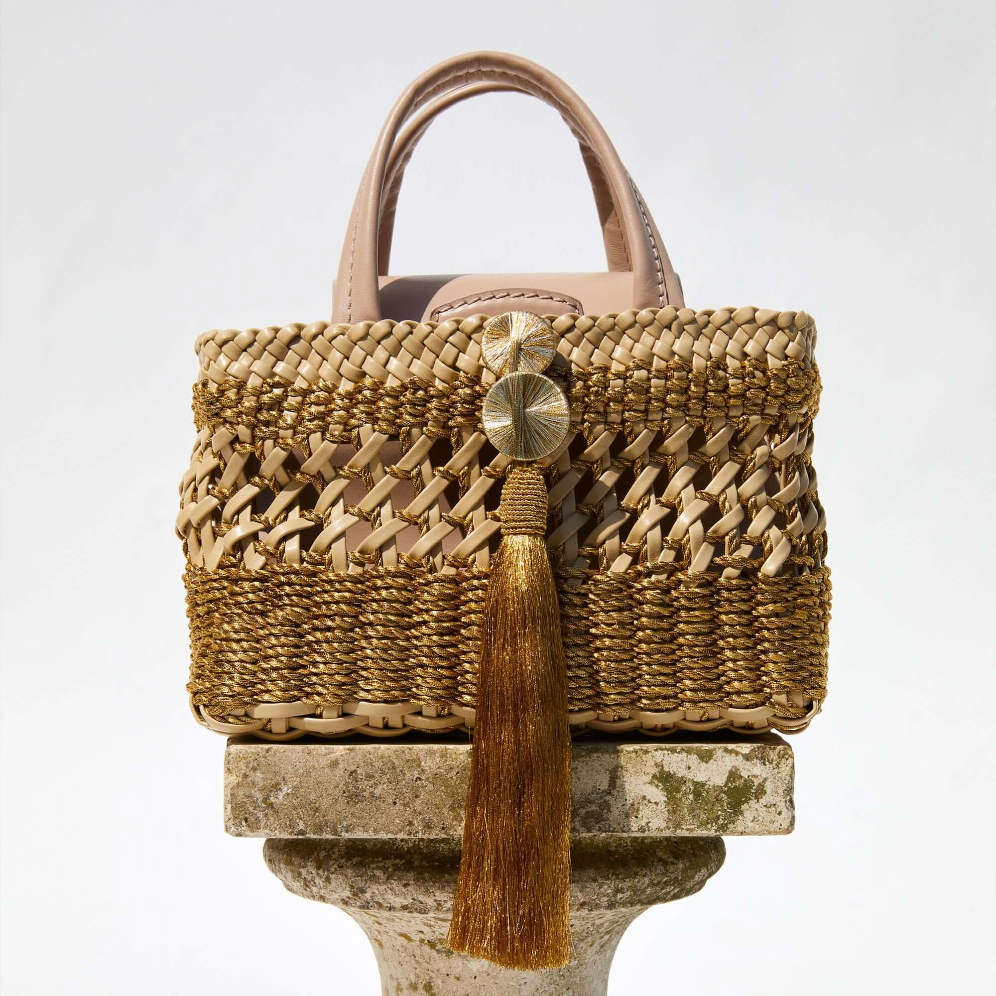 Almeria Sahara Mini Tote Bag showcasing intricate braided metallic leather and tassel detail in luxury design.