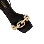 Top view of Catena black high-heel ankle sandal featuring antique gold chain embroidery on a sleek black satin upper.