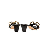 Catena Black Mid-Heel Sandal featuring antique gold chain link design, elegant footwear for refined style.