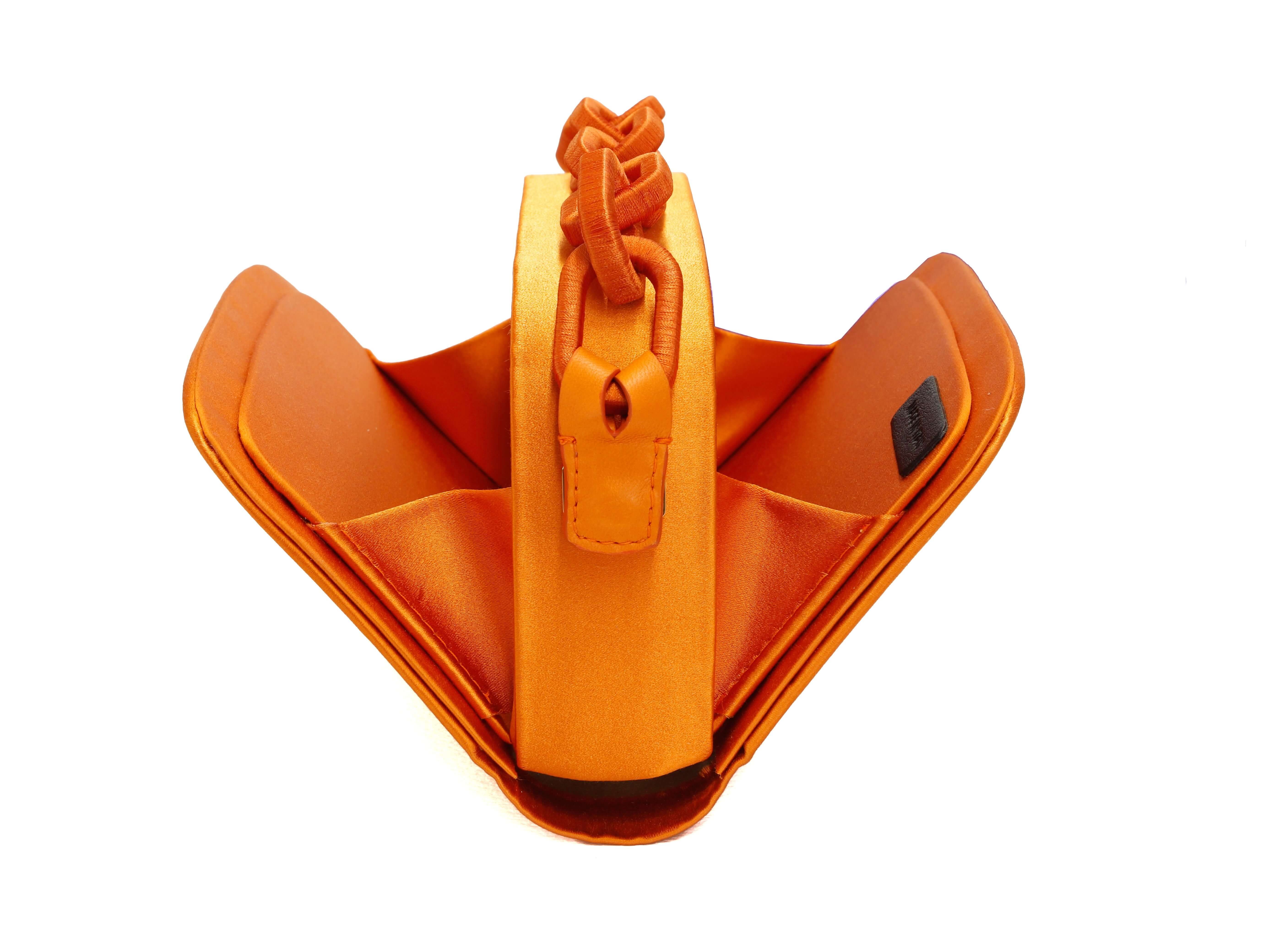 Catena Tangerine Two Sided Bag showcasing its vibrant orange color and unique folding design.