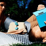 Two models lounging outdoors, one holding a Petra Turquoise Pouch Bag with natural stones, evoking a chic summer vibe.