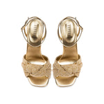 Rhea Gold Ankle Cross Sandal featuring metallic leather and braided crochet strap, elegant stiletto heel.