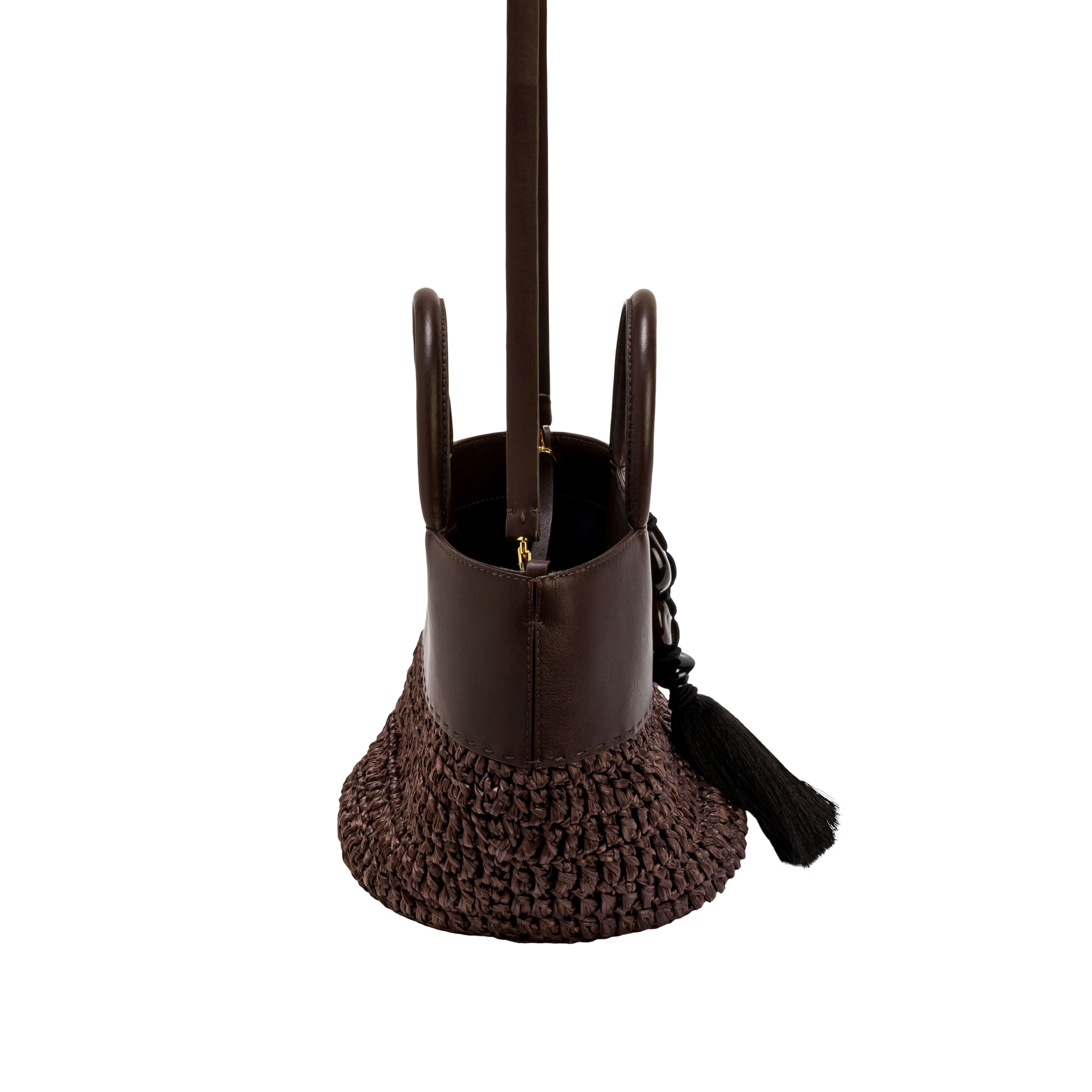 Elegant Melita Umber Mini Tote Bag showcasing luxurious handwoven raffia and a chic tassel detail.