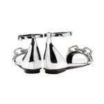 Catena Mirror Flat Ankle Sandal showcasing a sleek silver design with chain detail and an adjustable ankle strap.