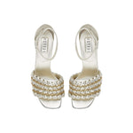 Elegant silver high-heeled sandals with unique braided design and ankle strap, perfect for formal occasions.