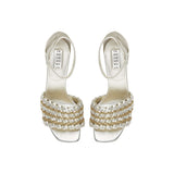 Elegant silver high-heeled sandals with unique braided design and ankle strap, perfect for formal occasions.