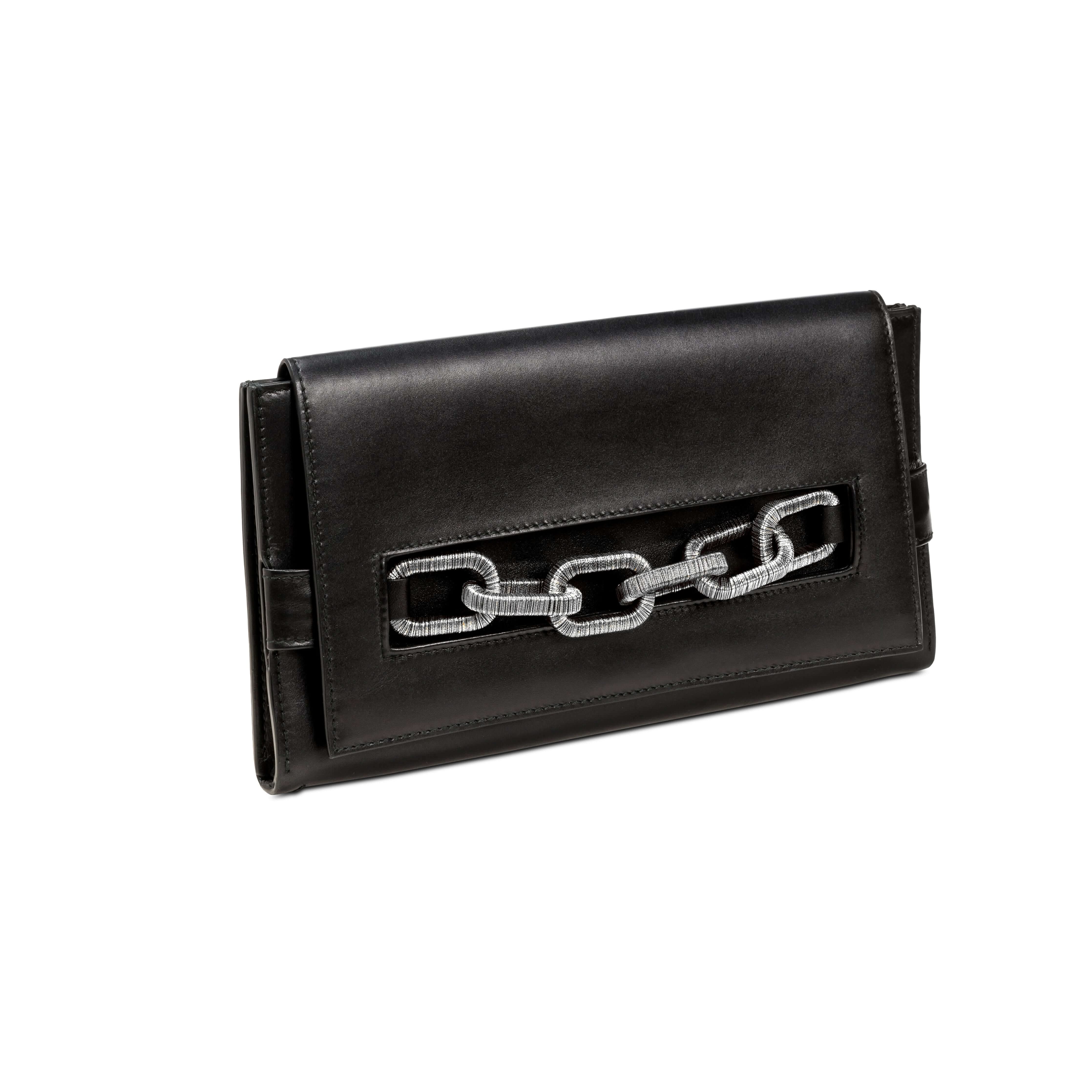 Elegant black clutch with antique silver chain detail for a sophisticated accessory look.