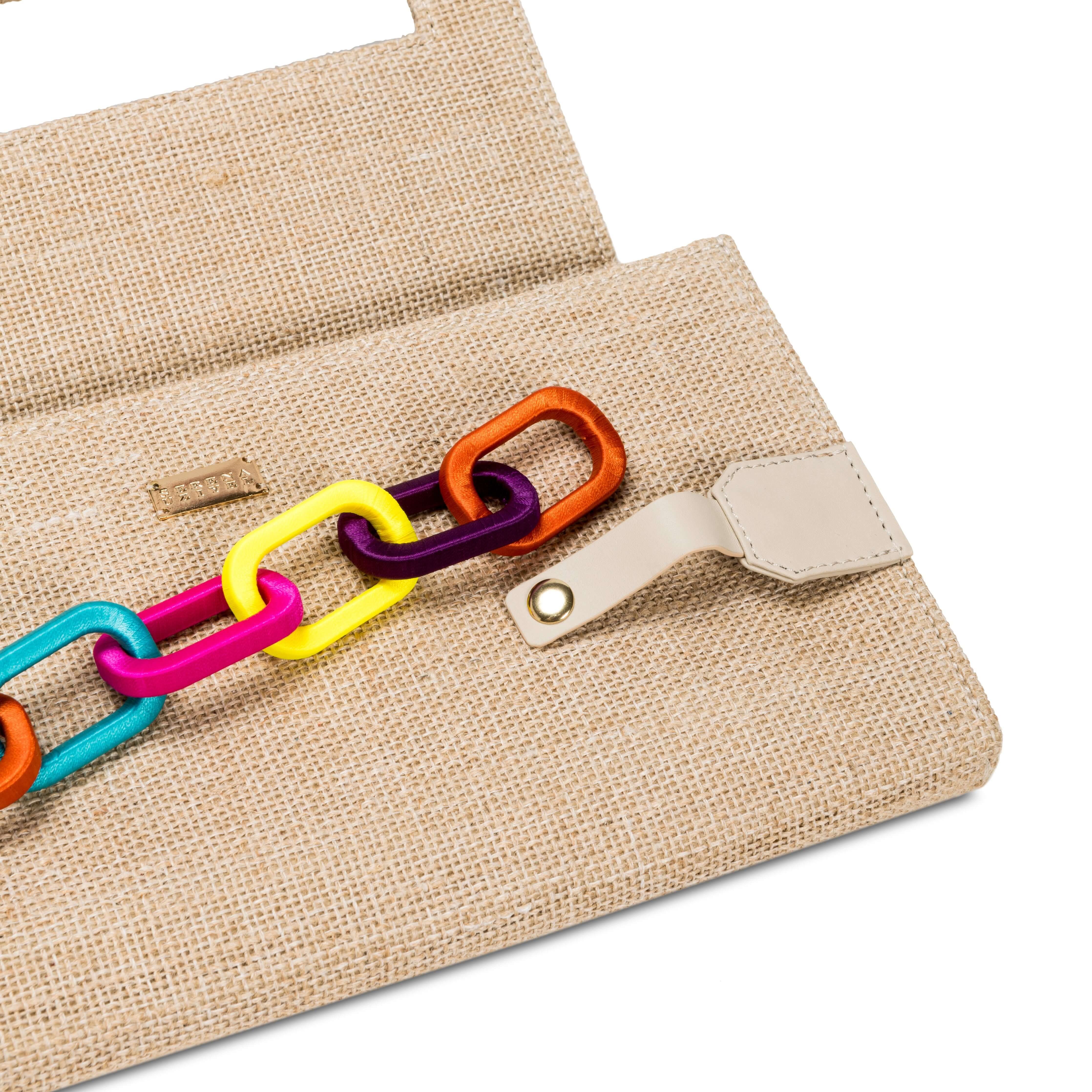 Catena Rainbow Chain clutch featuring a colorful chain design on a textured beige background.