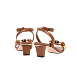 Delphine Camello mid-heel ankle cross sandals featuring a chic brown design with decorative details and secure buckle.