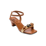Delphine Camello Mid-Heel Ankle Cross Sandal with decorative embellishments in tan color, perfect for stylish summer outfits.