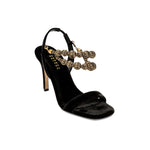 Elegant Lyra Black High-Heel Sandal featuring handwoven gold-embellished chains and a sleek silhouette.
