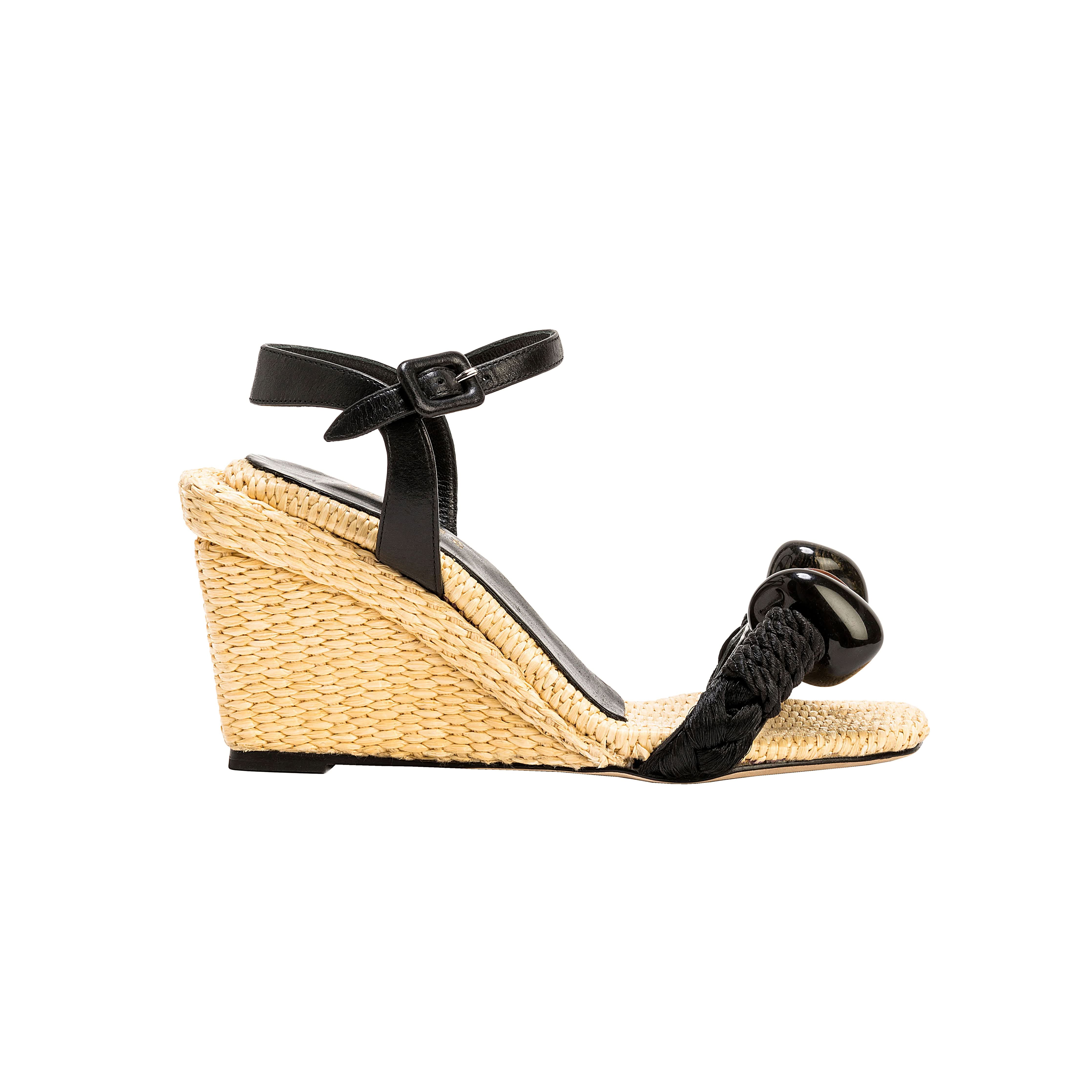Melita Natural Wedge Ankle Sandal featuring raffia and natural stone embellishments, with an eight-centimeter wedge heel.
