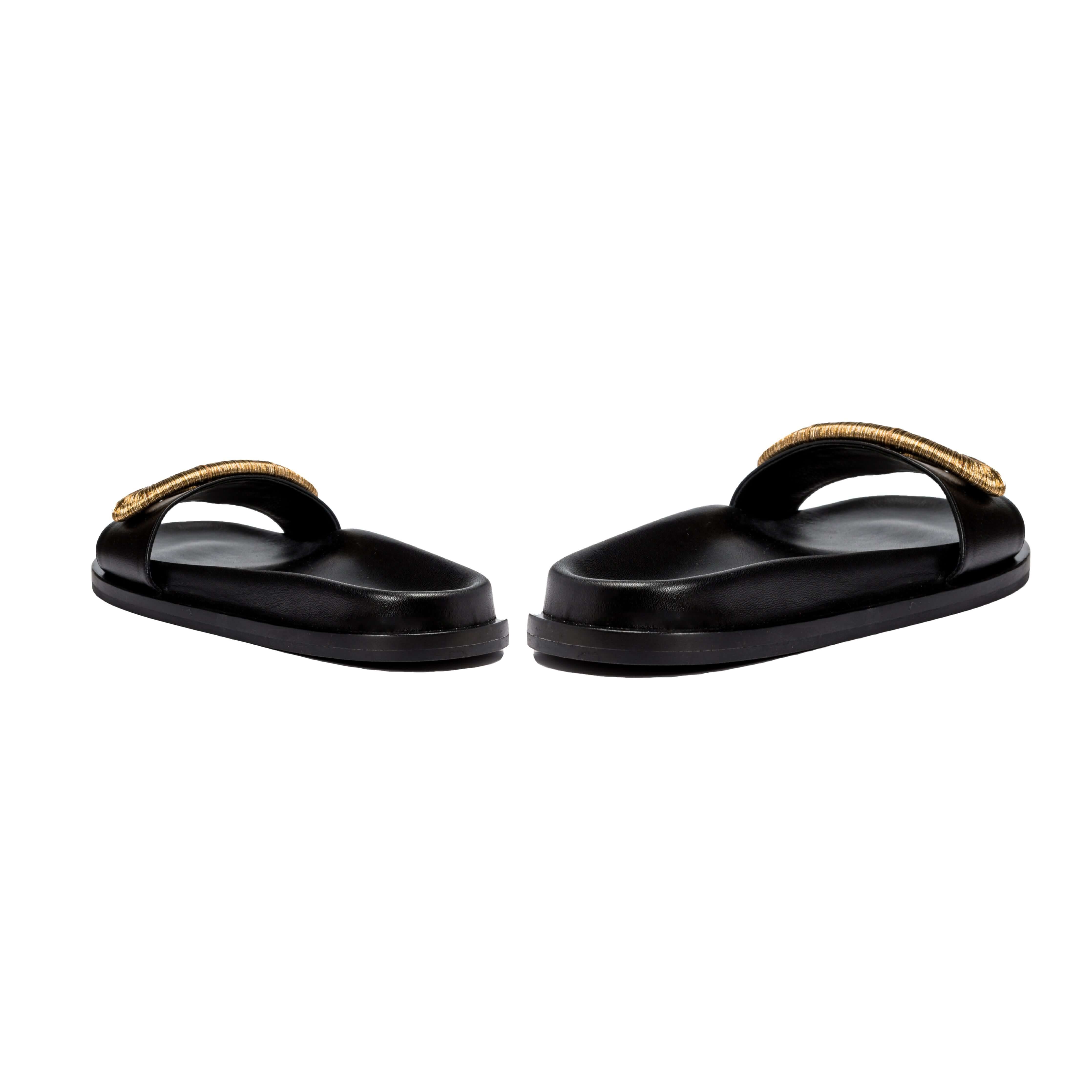 Naria Black Comfort Slide sandals with a stylish gold strap, offering casual elegance and comfort.