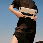 Model showcasing Thory Black Envelope Clutch against a clear sky, embodying sophistication and modern style.