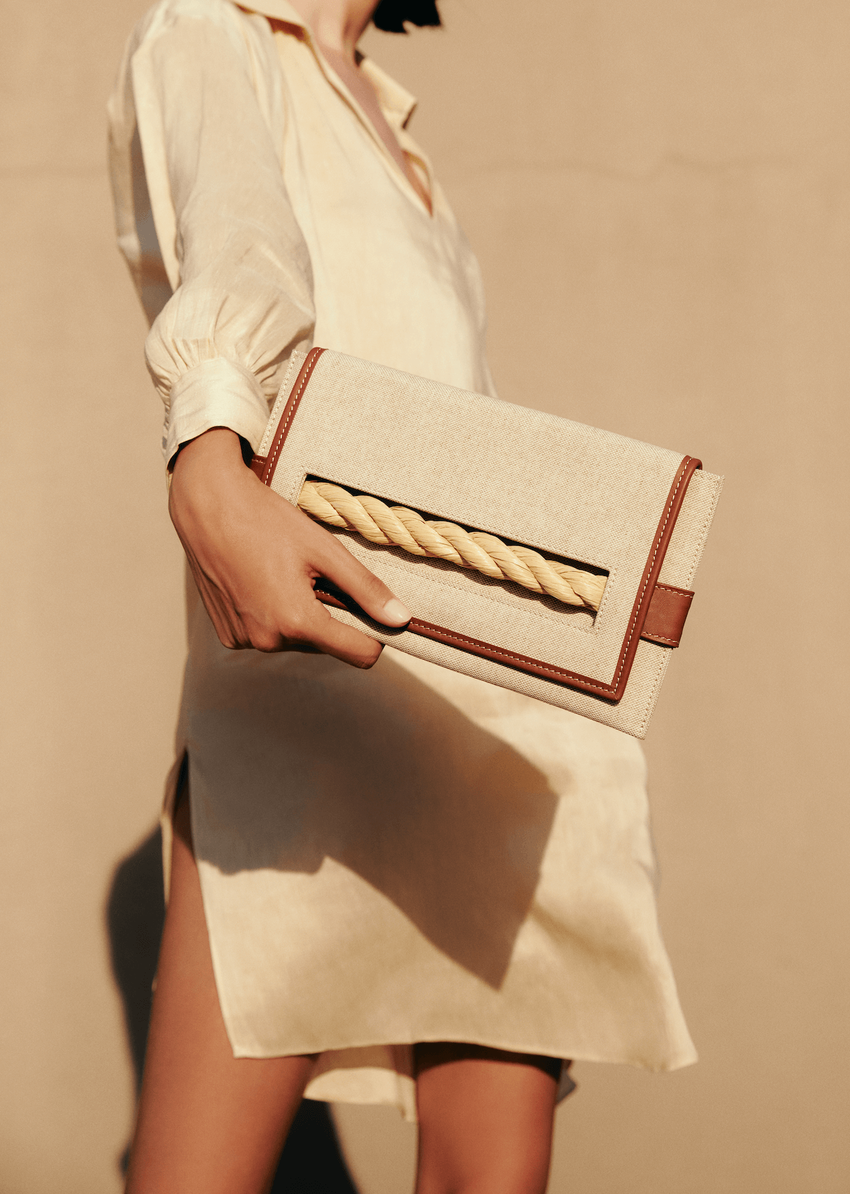 Thory Camello Envelope Clutch in natural canvas with camello leather trim, featuring a twisted raffia closure.
