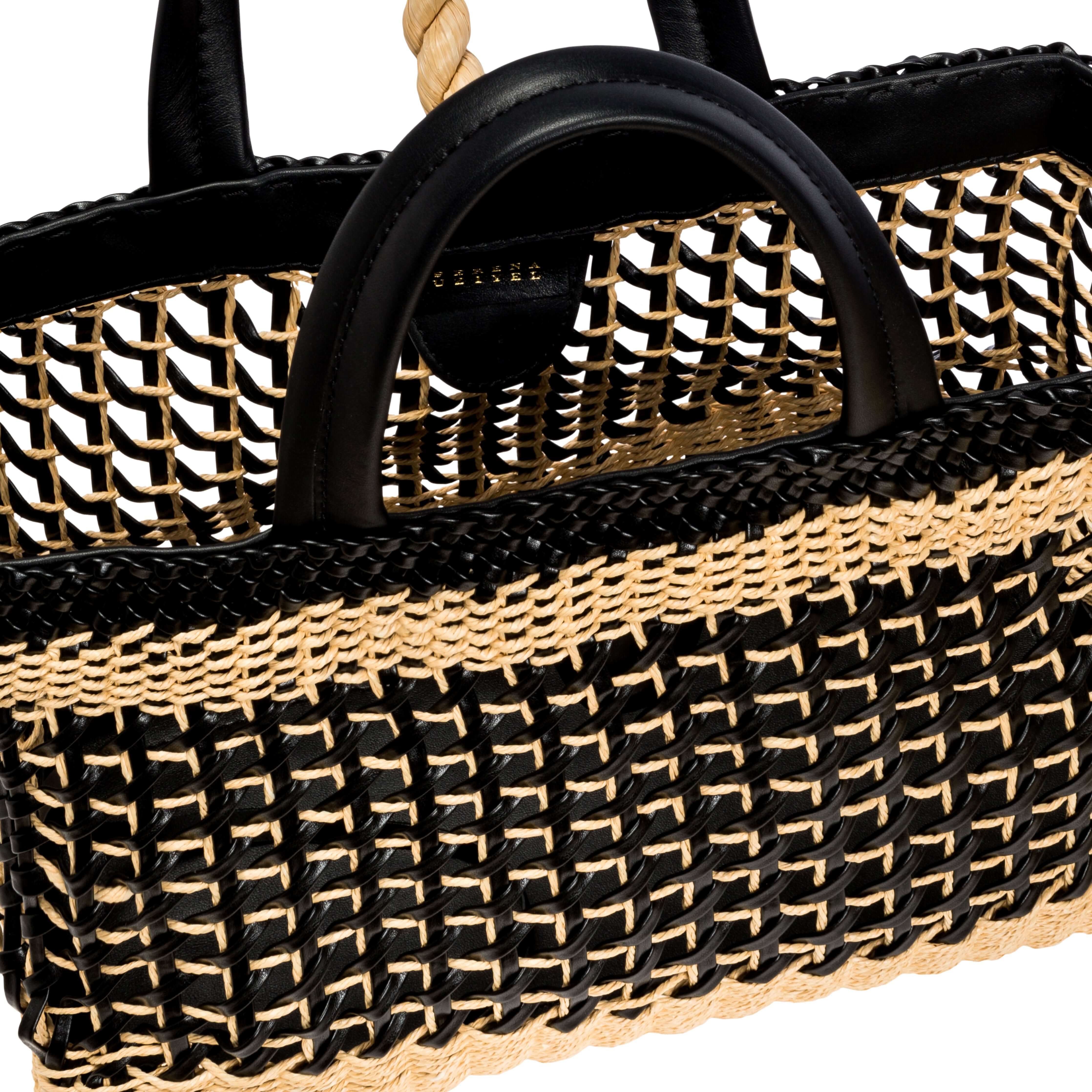 Stylish Almeria large shopping bag featuring elegant black and beige woven raffia, perfect for carrying essentials.
