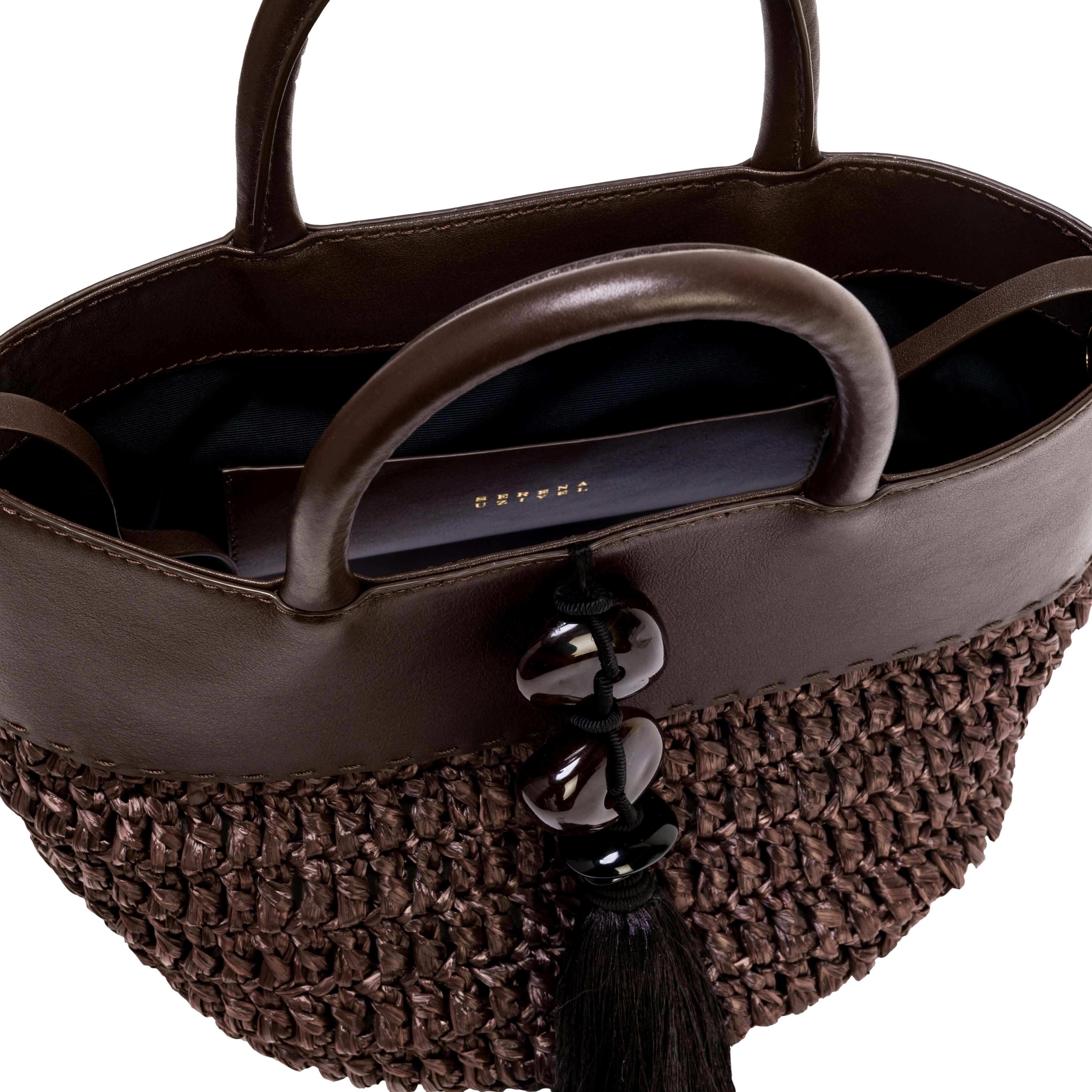Interior view of the Melita Umber Mini Tote Bag showcasing intricate raffia and stylish black tassel with natural stones.