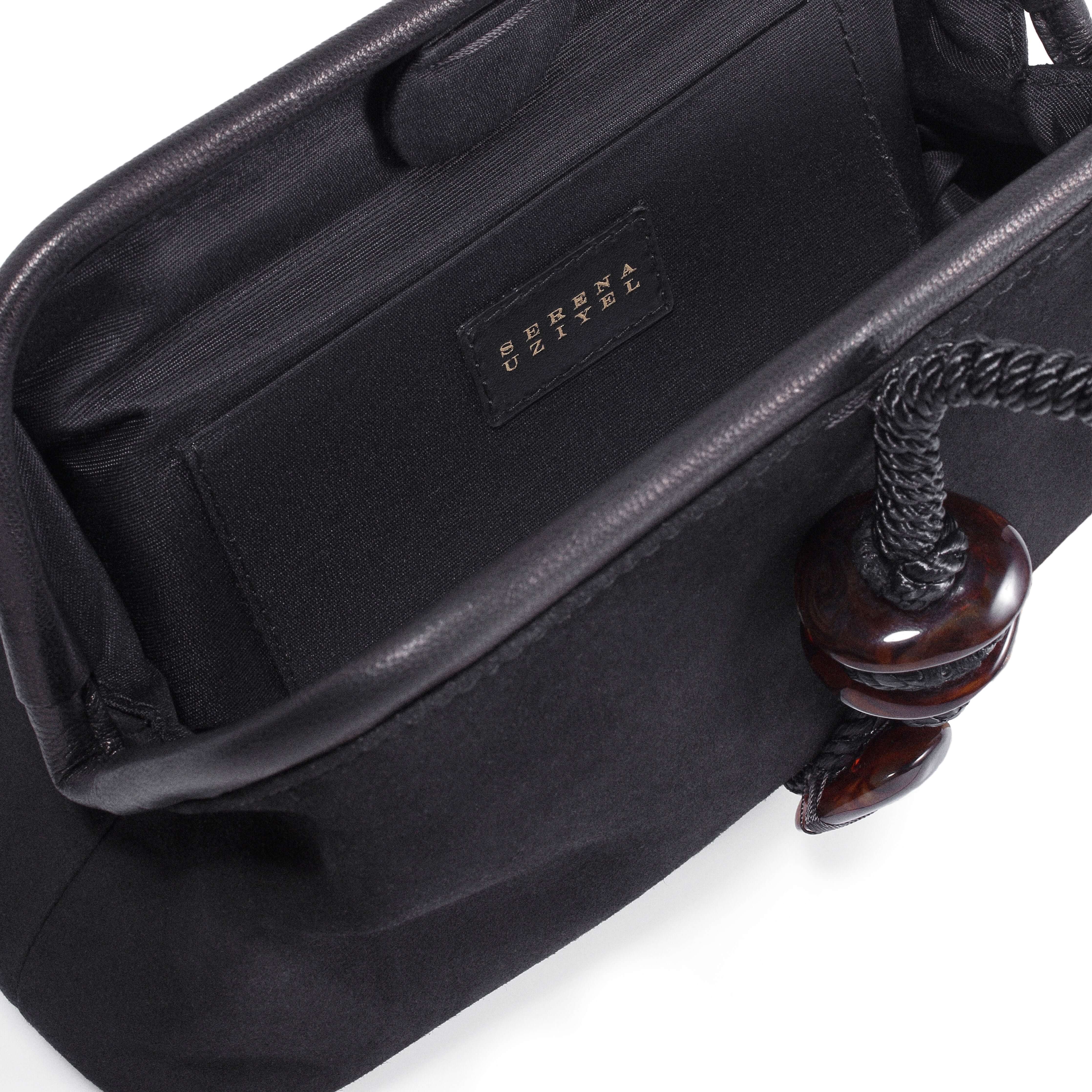 Inside view of the Petra Black Pouch Bag, featuring a suede leather interior and stylish detail.