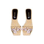 Taurea natural flat sandals made of sand-colored raffia with stone embellishments, perfect for summer wear.